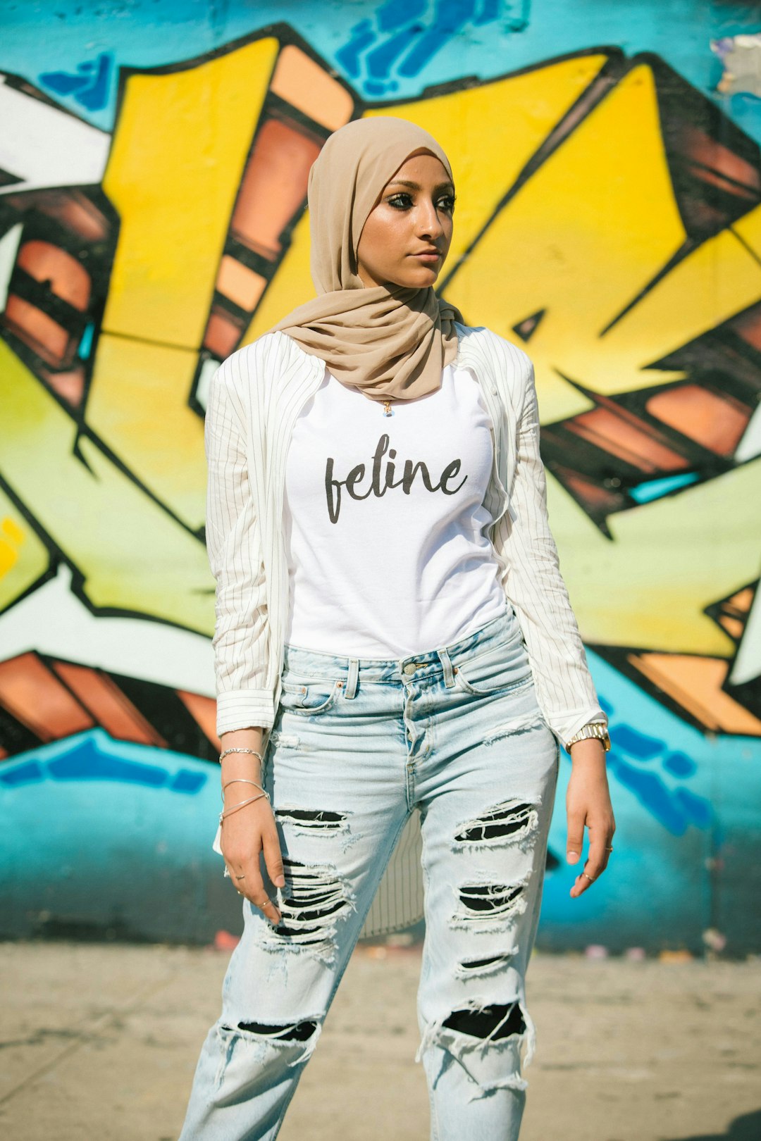 a-woman-standing-in-front-of-a-graffiti-wall-ktexpfadvyy